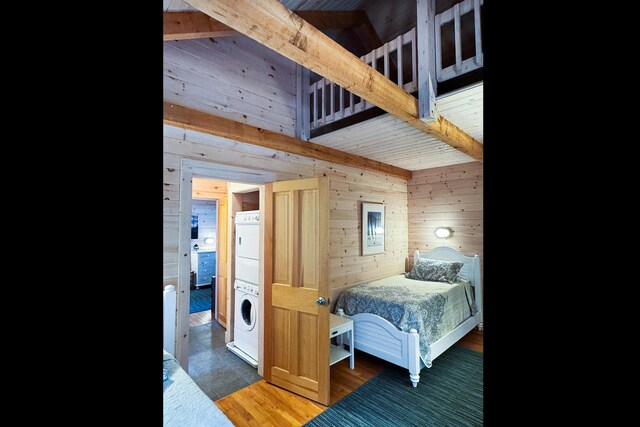 29 Good Day Dr, South Bristol, ME 04568 - bedroom with estacked washer and dryer, wooden walls, and beamed ceiling
