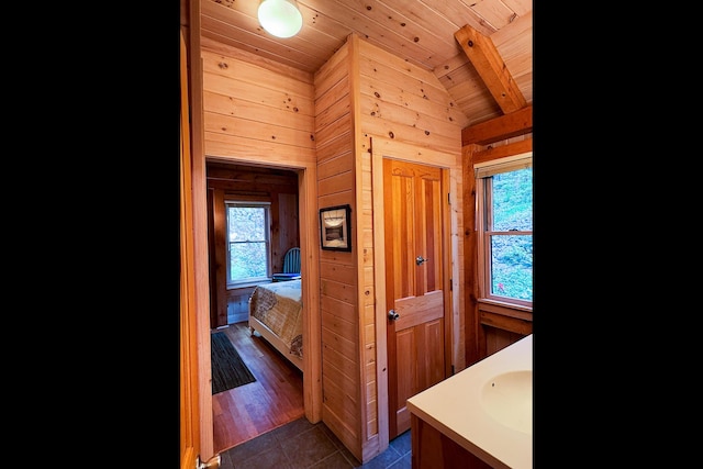 29 Good Day Dr, South Bristol, ME 04568 - ensuite bathroom with lofted ceiling, vanity, wood ceiling, tile patterned flooring, and wood walls