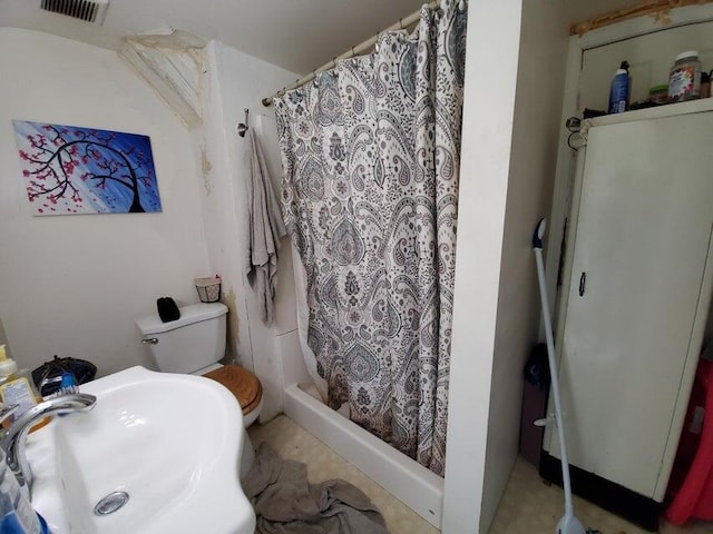 bathroom featuring a stall shower, toilet, visible vents, and a sink
