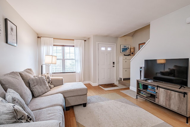 living area featuring light wood finished floors and baseboards