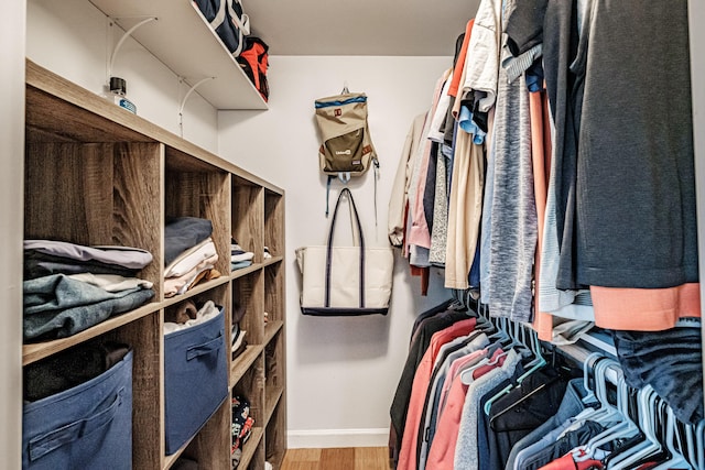 walk in closet with light wood-style floors