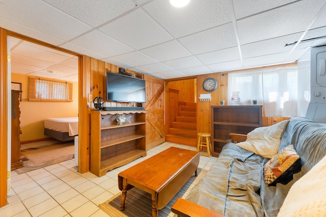 11 Elm Dr, York, ME 03909 - living room featuring a paneled ceiling, wooden walls, tile patterned flooring, and stairs