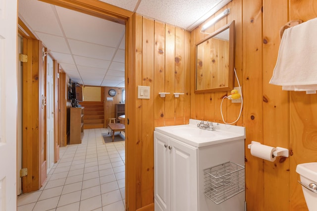 11 Elm Dr, York, ME 03909 - bathroom with vanity, a paneled ceiling, tile patterned flooring, toilet, and wood walls