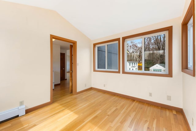 11 Elm Dr, York, ME 03909 - empty room with baseboards, light wood-type flooring, a baseboard heating unit, and vaulted ceiling