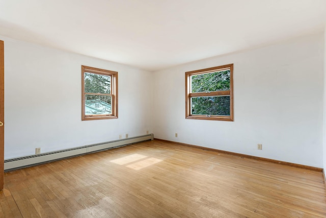 11 Elm Dr, York, ME 03909 - unfurnished room with light wood-style flooring, a baseboard heating unit, baseboards, and a healthy amount of sunlight