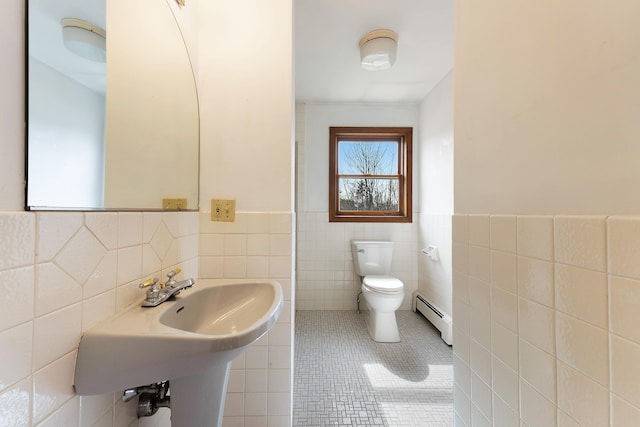 11 Elm Dr, York, ME 03909 - bathroom featuring a wainscoted wall, toilet, tile walls, a baseboard radiator, and tile patterned floors