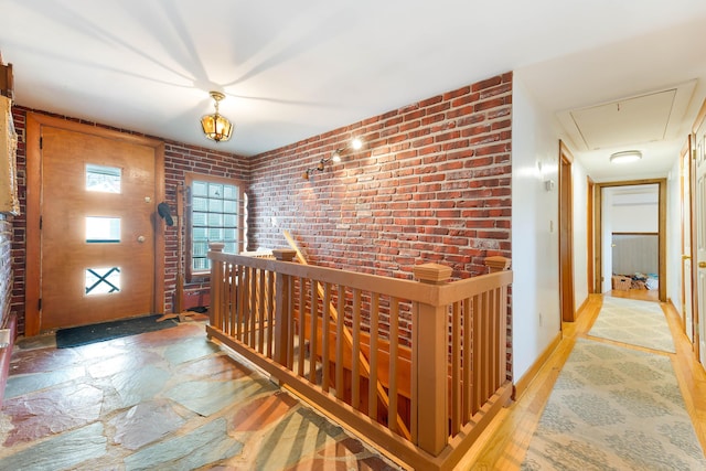 11 Elm Dr, York, ME 03909 - hallway featuring stone tile flooring, an upstairs landing, attic access, and brick wall