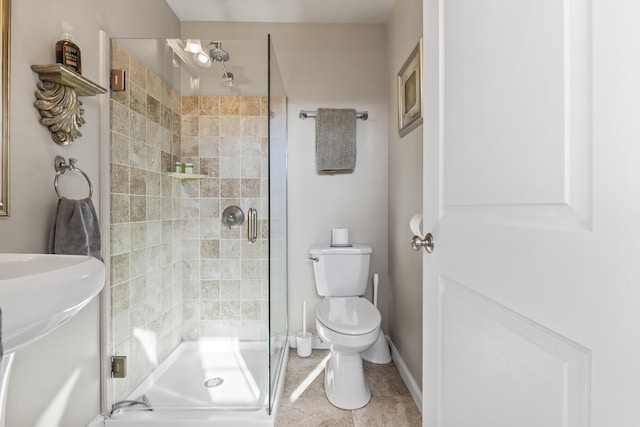 bathroom with tile patterned floors, a shower stall, toilet, and baseboards