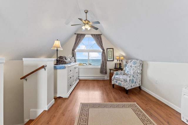 living area featuring an upstairs landing, a ceiling fan, light wood-type flooring, and a baseboard radiator