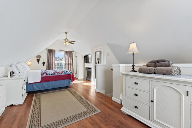 bedroom featuring ceiling fan, baseboards, wood finished floors, and vaulted ceiling