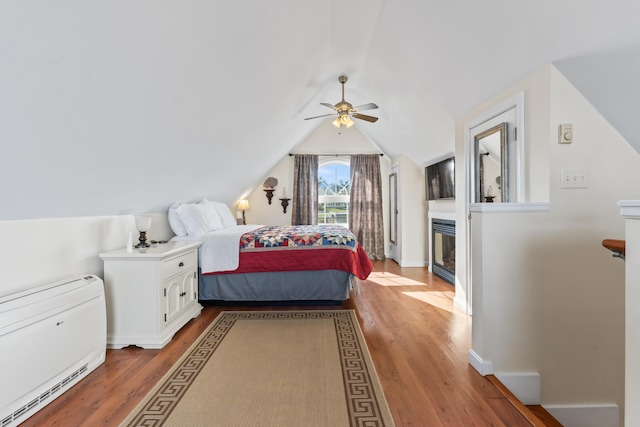 bedroom with lofted ceiling, baseboards, and light wood finished floors