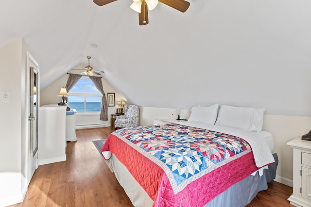 bedroom with a ceiling fan, lofted ceiling, wood finished floors, and a baseboard radiator