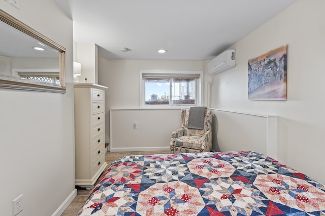 bedroom featuring light wood finished floors, recessed lighting, baseboards, and a wall unit AC