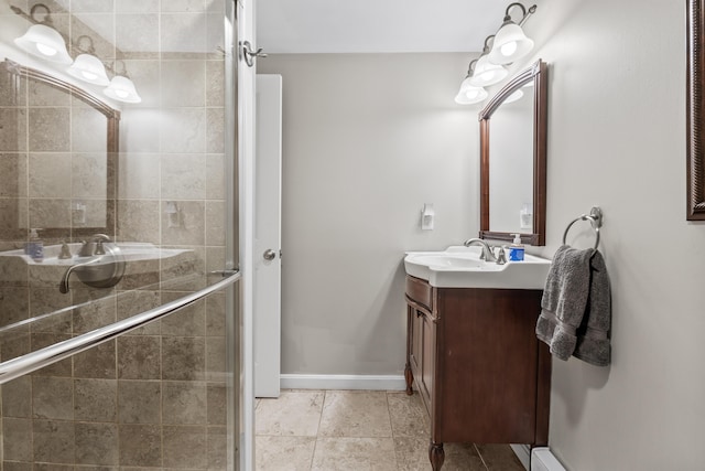 full bath featuring vanity, baseboards, tile patterned flooring, a shower stall, and a baseboard heating unit