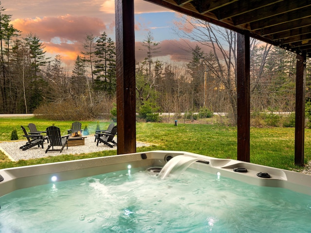 view of swimming pool with a patio, a lawn, a hot tub, and a fire pit
