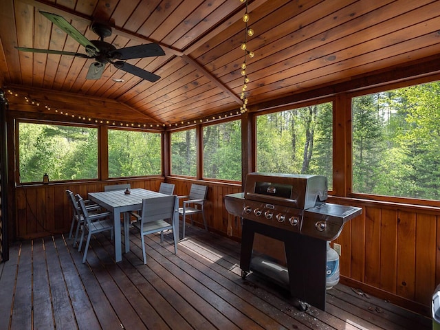 sunroom featuring wood ceiling, a ceiling fan, and vaulted ceiling