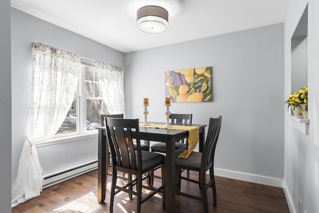 dining area with baseboards, baseboard heating, and wood finished floors