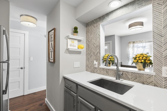 kitchen featuring gray cabinets, a sink, open shelves, freestanding refrigerator, and light countertops