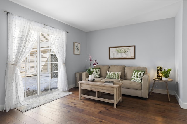 living area with baseboards and hardwood / wood-style flooring