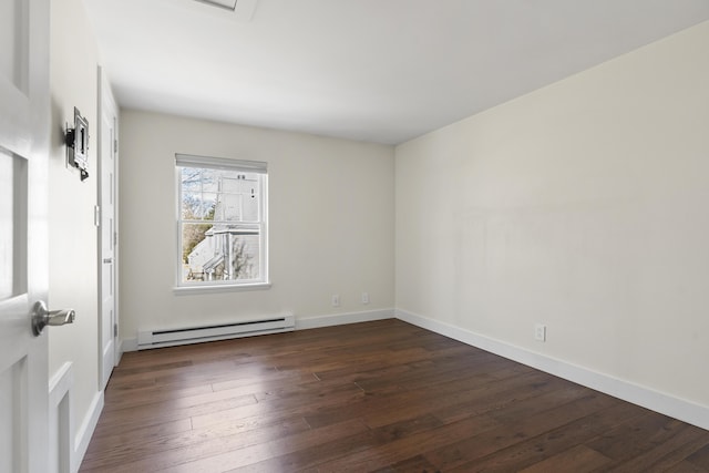 spare room featuring a baseboard radiator, baseboards, and dark wood finished floors