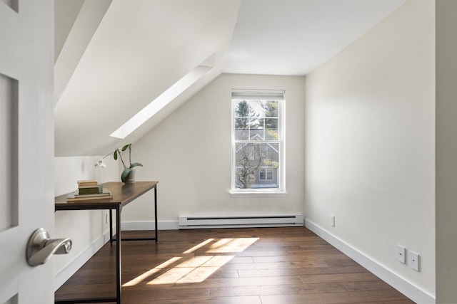 unfurnished office featuring lofted ceiling with skylight, baseboards, wood-type flooring, and a baseboard radiator