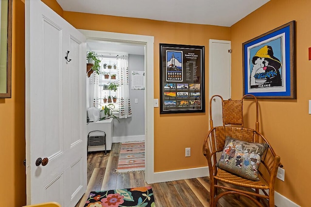 living area with baseboards and wood finished floors
