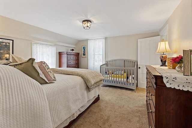 bedroom with multiple windows, light colored carpet, and lofted ceiling