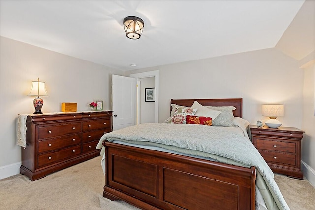 bedroom featuring light colored carpet and baseboards