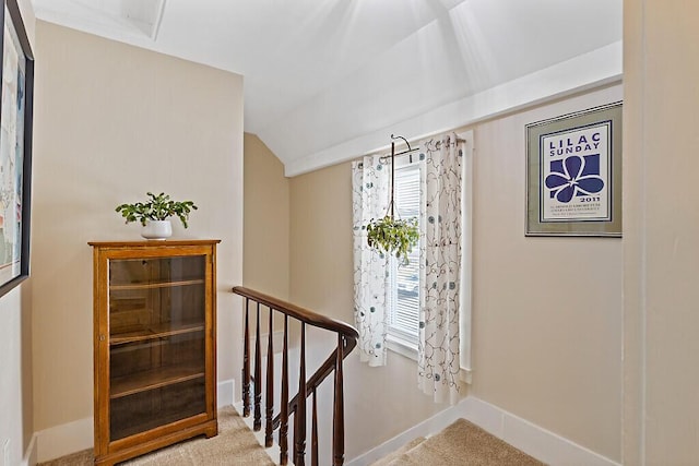 stairs featuring lofted ceiling, baseboards, and carpet floors