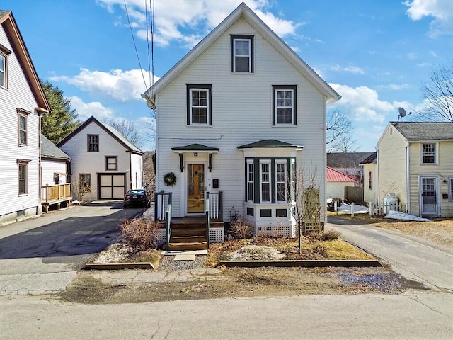 traditional style home with aphalt driveway and an outbuilding