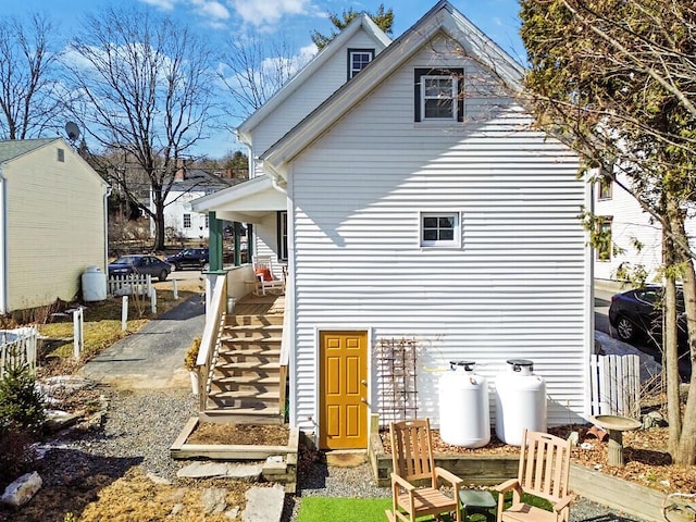 back of property featuring stairway and fence