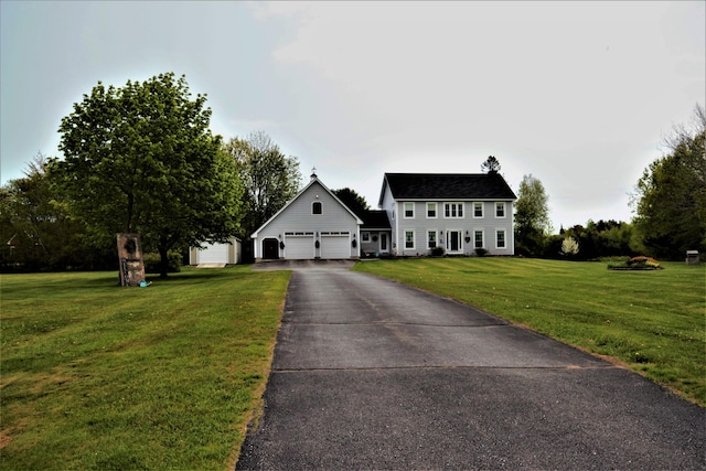 colonial-style house featuring a garage, driveway, and a front yard