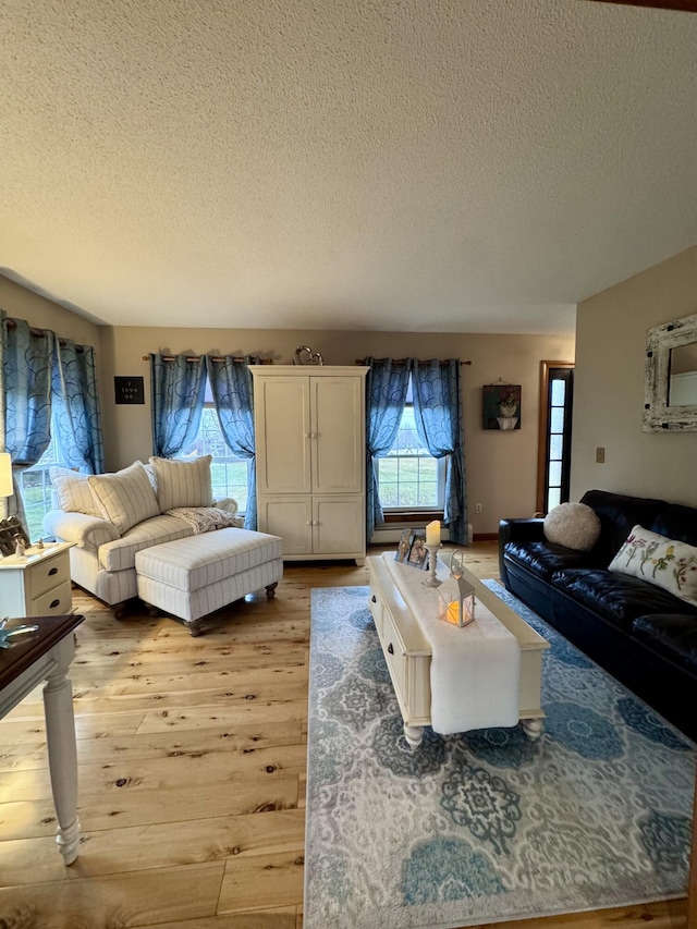 living area with light wood-style floors and a textured ceiling