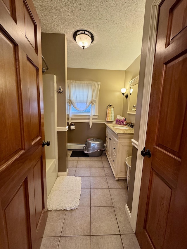 full bathroom featuring tile patterned flooring, tub / shower combination, baseboard heating, a textured ceiling, and vanity