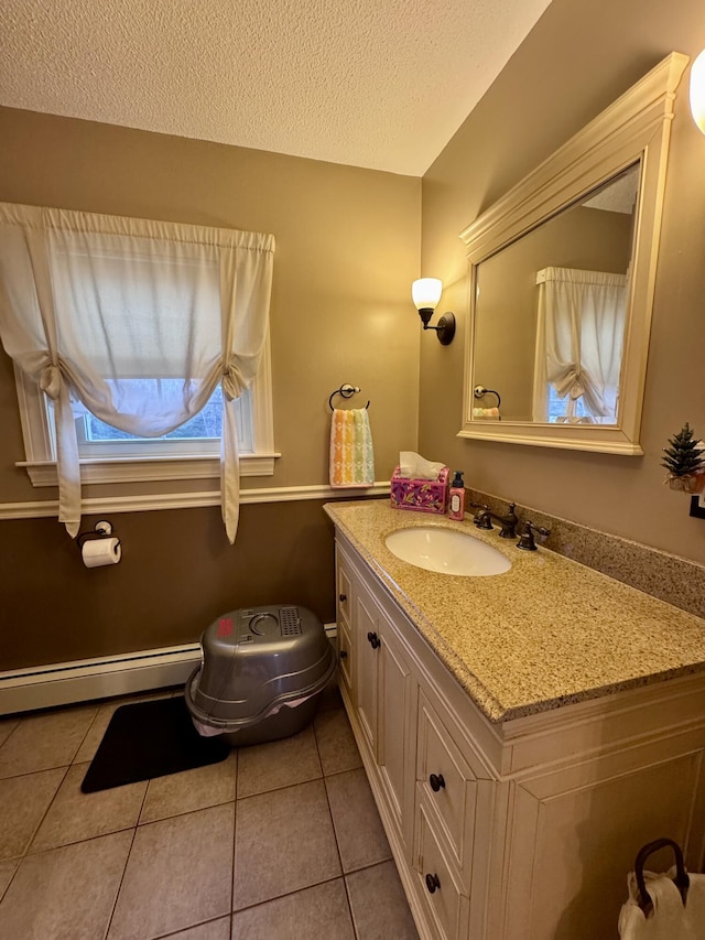 bathroom featuring vanity, tile patterned floors, baseboard heating, and a textured ceiling