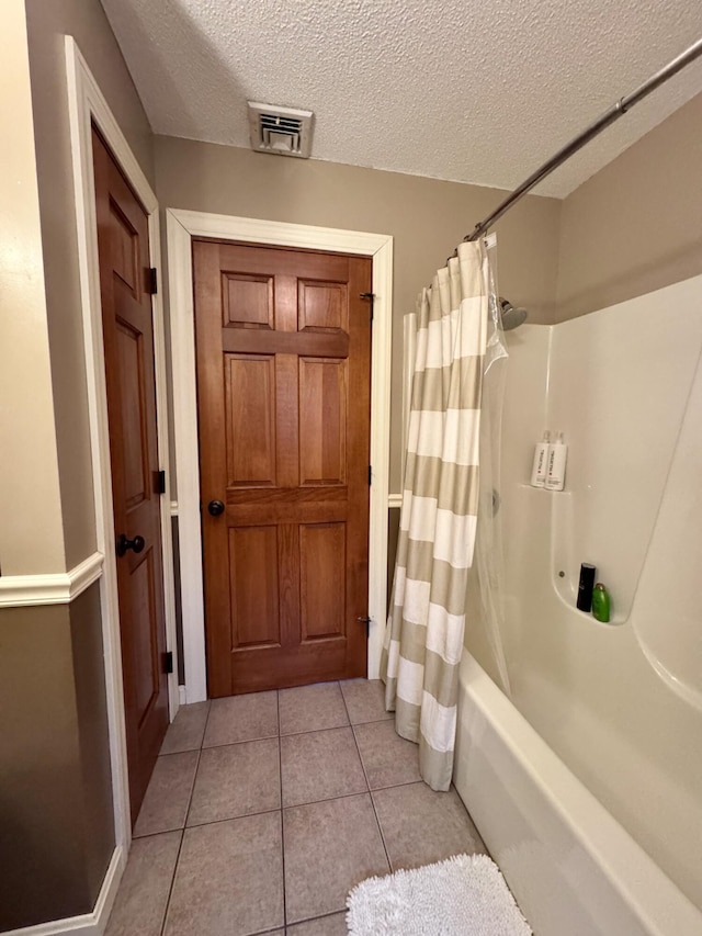 full bath with visible vents, a textured ceiling, and tile patterned flooring