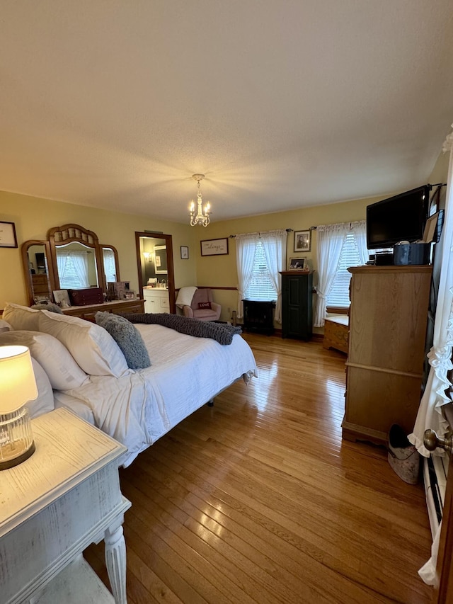 bedroom featuring an inviting chandelier and hardwood / wood-style flooring