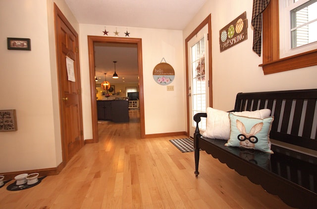 hall featuring baseboards and light wood-type flooring