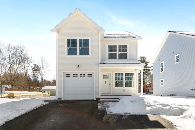 traditional home featuring aphalt driveway and an attached garage