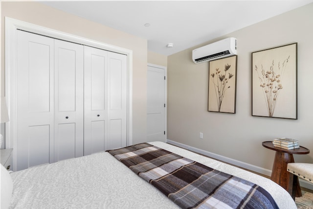 bedroom featuring a closet, baseboards, and an AC wall unit