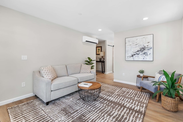 living room featuring a wall mounted air conditioner, baseboards, and wood finished floors