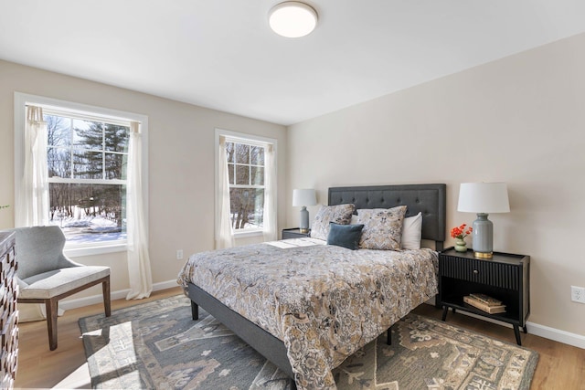 bedroom with light wood-type flooring and baseboards