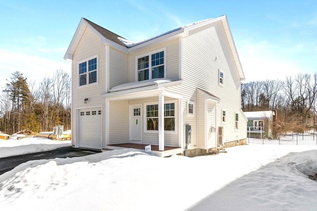 traditional-style home with aphalt driveway, an attached garage, and fence