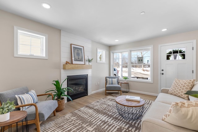 living room featuring plenty of natural light, recessed lighting, a fireplace, and light wood-type flooring