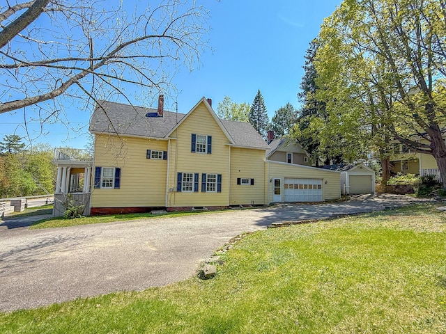 39 Washington St, Rumford, ME 04276 - view of home's exterior with a chimney, a detached garage, a yard, and roof with shingles