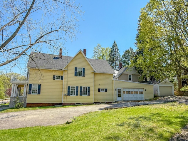 39 Washington St, Rumford, ME 04276 - rear view of property with driveway, a yard, a chimney, a shingled roof, and an attached garage