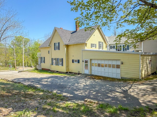 39 Washington St, Rumford, ME 04276 - view of property exterior with asphalt driveway, roof with shingles, a chimney, and an attached garage