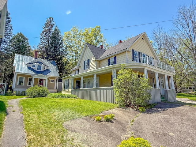 39 Washington St, Rumford, ME 04276 - view of side of home featuring covered porch, a chimney, a lawn, and a balcony