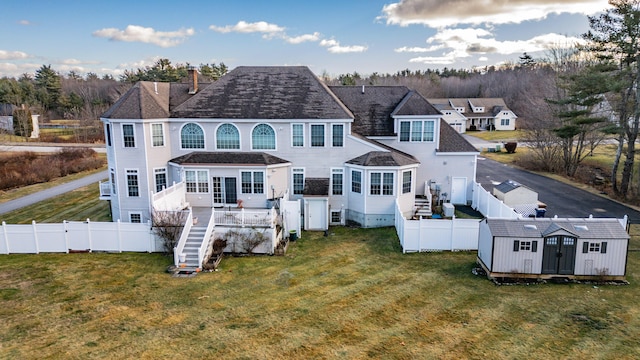 16 Ocean Greens Dr, Saco, ME 04072 - back of house featuring a fenced backyard, a lawn, an outbuilding, and a storage shed