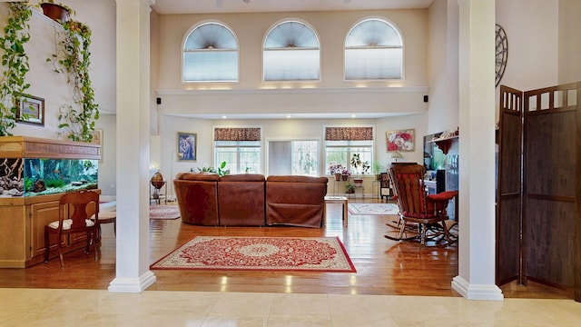16 Ocean Greens Dr, Saco, ME 04072 - living area featuring decorative columns, wood finished floors, and a towering ceiling